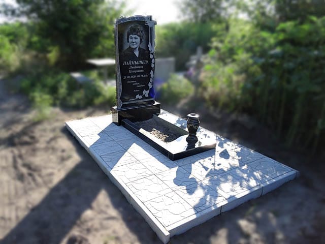 monument with a cross and a twig for a woman a man