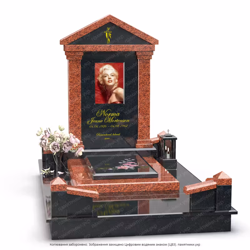 Памятник в виде храма с треугольной крышей из красного и черного натурального камня.